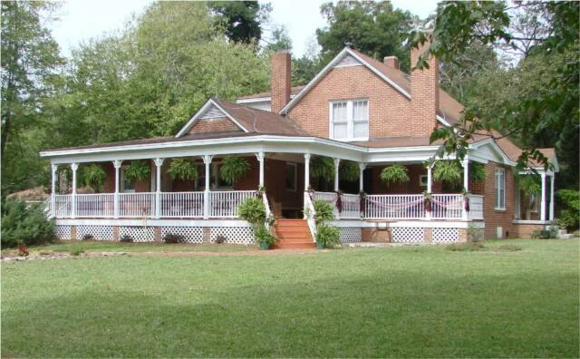 Heartfriends Inn from the lawn, its wrap-around porch hung with ferns